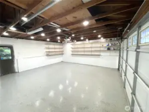 Another view of garage shows shelving and epoxy floor.