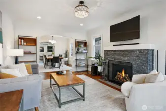 Warm and inviting living room with fireplace, hardwood floor leaded glass windows and coved ceiling.