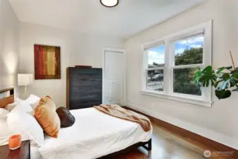 Main floor bedroom with hardwood floor and double pane windows.