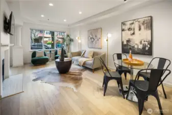 Main floor features open-concept kitchen and living area with abundant natural light, cozy gas fireplace, and powder room.