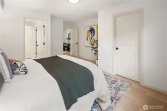 In the bedroom, door to the left leads to your en suite bath, in the middle of the frame, we can see the desk out in the flex space, and to the right is your large walk-in closet