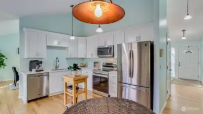 A view of the brand new kitchen, showcasing sleek white cabinets, quartz counters and all new appliances.