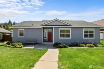 Charming covered entry with a welcoming walkway leading to a bright, inviting home.