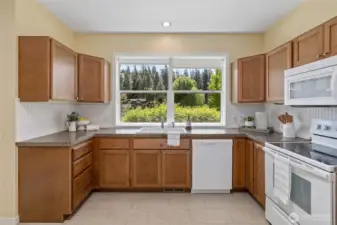 Airy kitchen with large windows, cozy charm, and practical design.