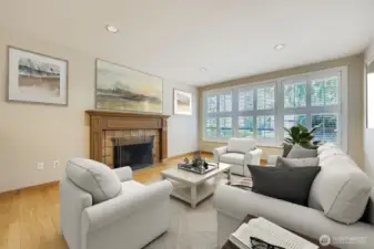 The gas fireplace in the living room features a tile hearth and carved oak mantle. Beautiful wall of windows with plantation shutters.  Fresh interior paint.