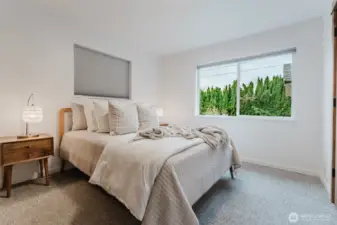 Bright and comfortable primary bedroom with neutral tones and newer windows.