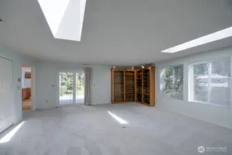Enormous adjoining family room with skylights and built-in bookcases