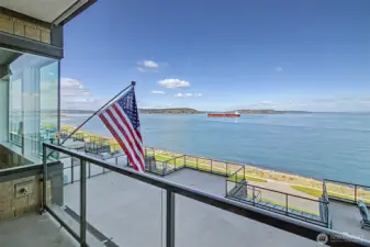 Private balcony showcases panoramic bay views and passing marine traffic.