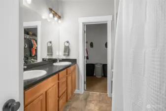 Primary Bath hosts double sinks, walk-in shower, & a walk-in closet