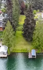 Drone view of lot from lake looking up to street