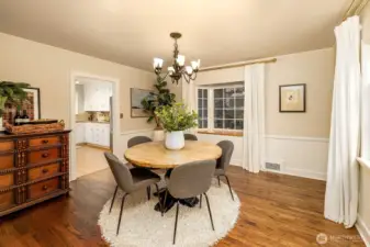 Large, formal dining room easily accommodates 10 guest and is drenched in natural light and new curtains and hardware. Gleaming refinished hardwood floors capture the natural light coming in from the windows.