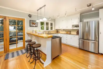 Open kitchen for ease of entertaining and access to western facing deck and access to the backyard. Newer Bosch dishwasher and gas range with electric oven for easy cooking.
