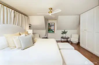 Top floor primary suite shown here with a king sized bed leaving ample space for seating or storage.
