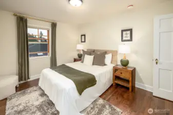 Another view of the bedroom highlights the consistent, thoughtfully selected door hardware carried throughout the home.
