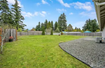 The back yard is spacious and mostly flat. The heat efficient pump is on the right, offering both efficient heating and cooling.  The awesome back yard is perfect for play, gardening, and relaxing.