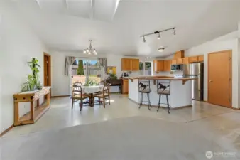 From the great room looking into the dining area and kitchen. The door on the right is the pantry. The sliding door leads to the mostly flat, spacious back yard. Vinyl flooring makes for easy maintenance all around.