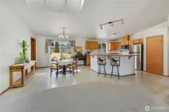 From the great room looking into the dining area and kitchen. The door on the right is the pantry. The sliding door leads to the mostly flat, spacious back yard. Vinyl flooring makes for easy maintenance all around.