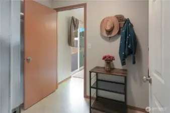 This utility/mud room off of the garage leads directly to the dining and kitchen area. The sliding door in the background leads to the spacious, fenced back yard.