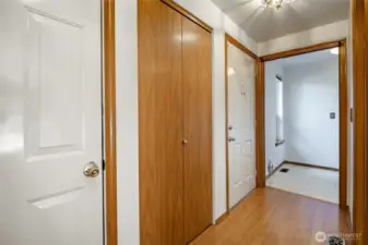 entry. Door to the left in the foreground goes to the garage. Laundry Room in the background. 1/2 bathroom to the right.