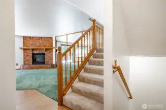 Living room. Stairs going up to bedrooms and 2 full bathrooms. Stairs going to lower level to the right.