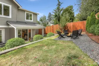 Manicured back yard with fire pit space.