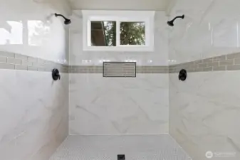 The newly remodeled primary bathroom shower with dual shower heads.