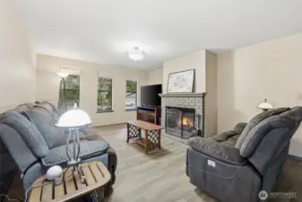 The wood-burning fireplace is a beautiful and inviting focal point in this freshly-painted, comfortable family foom.