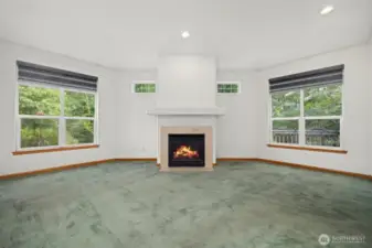 The living room is very spacious and looks out to the greenbelt with a stream running through it.