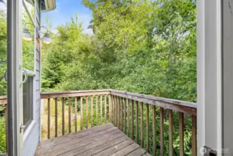 The deck off the primary suite is very private and looks out to a greenbelt with a stream running through it.