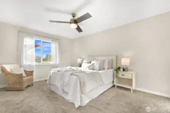 Spacious primary bedroom with large open windows for natural light.