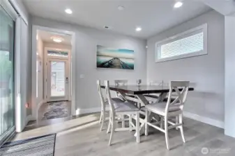 Adjacent to the gathering room, the large dining area effortlessly hosts an 8-person table, making it perfect for dinner parties or family meals. The two spaces are separated by a wide, elegant transition that showcases a luxurious feel and meticulous craftsmanship, creating flow while highlighting the home’s attention to detail.Enjoy direct access to your private deck, seamlessly blending indoor and outdoor living. Whether it’s morning coffee, evening relaxation, or entertaining guests, this easy flow makes the deck an extension of your home’s gathering spaces.