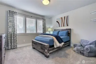 The spacious first bedroom to the left is both comfortable and inviting, featuring a large walk-in closet and a conveyed 42-inch TV—perfect for relaxation and personal space.