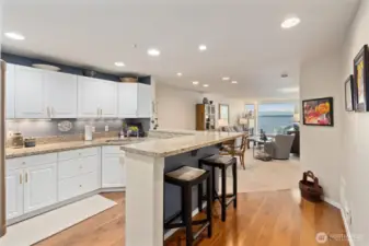 The kitchen boasts updated appliances and an ample breakfast bar, perfect for friends to gather while you prepare your favorite meals—combining style, functionality, and social living in one space.