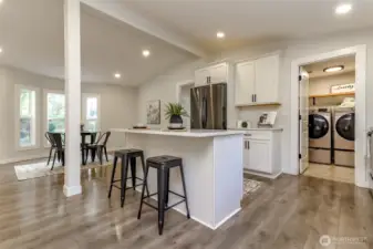 Kitchen facing the utility room. There are large storage cabinets behind the utility door great for additional pantry space. Back door to the right of washer and dryer onto covered back porch.