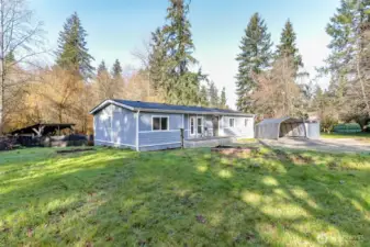 This angle of the front of the house shows the covered lean to in the backyard. Perfect for storing dry firewood for backyard firepit area.