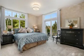 Spacious primary bedroom with ensuite bath, walk-in closet and sliders off to deck.