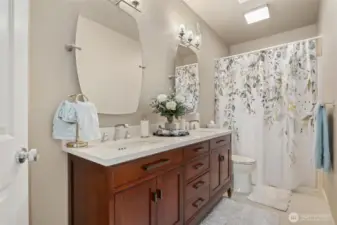 3/4 ensuite bath on the main level in the primary bedroom suite. Dbl vanity with under counter sinks, and quartz countertops. Nice!