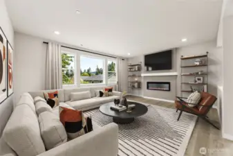 Great room with fireplace, and large windows for natural light. Photo is of actual home virtually staged.