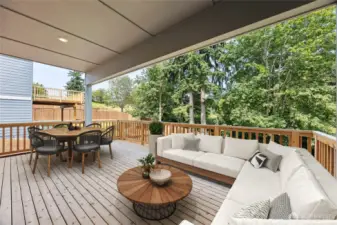 Covered deck area with backdrop of trees. Photo of actual home with virtual staging.