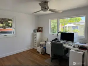 Large 2nd bedroom/office on main level newly painted with hardwood flooring ceiling fan and large windows to view yard and nature settings