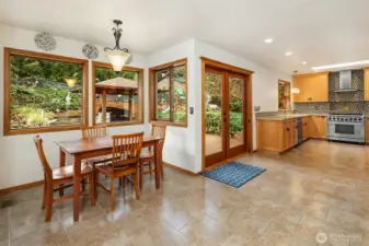Eating nook and kitchen with the doors to the outdoor kitchen and yard.