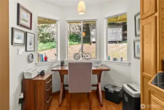The breakfast nook is currently used as a personal office, with bay windows and a view of the backyard.