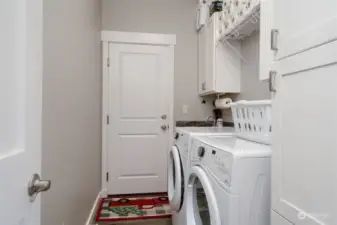 Utility room off of garage with cabinet storage. Appliances stay!