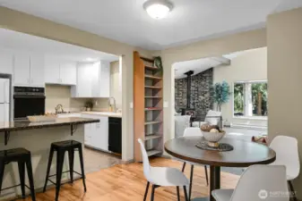 Open kitchen with bar seating and dining nook, flowing into a spacious family room.