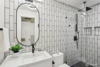 Remodeled bathroom with modern features such as a rainfall shower head.