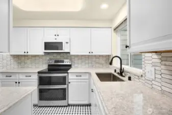 Updated kitchen w/quartz counters & tiled modern backsplash.