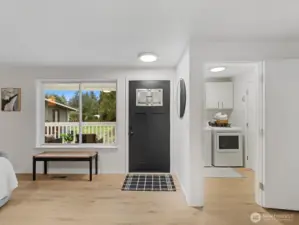 Bright entryway with modern front door, large picture window, and convenient access to the laundry room and garage