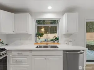 Bright kitchen with white cabinetry, quartz countertops, new dishwasher, and large stainless sink