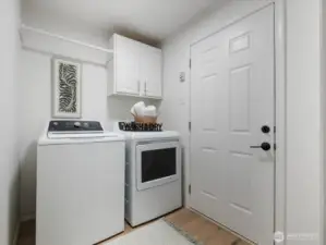 Laundry with new washer and gas dryer off garage, with cabinet space