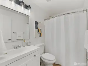 Updated main bathroom featuring a modern vanity, LVP flooring, clean finishes and tub/shower combination, and